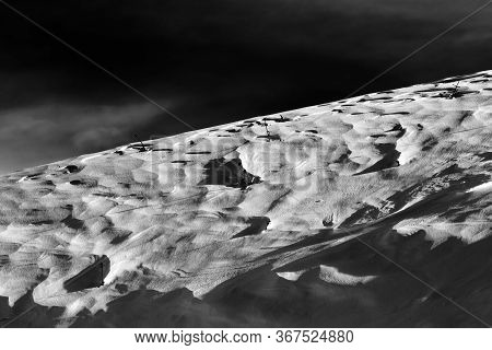 Off-piste Snowy Slope At Windy Winter Night After Snowfall. Black And White Toned Landscape. High Co