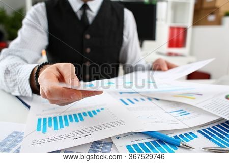 Close-up Of Businessman Working With Papers In Office. Documents With Graphs And Diagrams. Monthly R