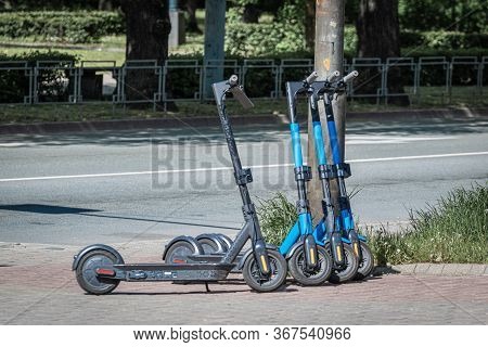 Blue Dockless Electric Scooters On The Sidewalk. Alternative Transport.