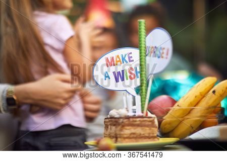 Slice of sweet birthday cake on  party with  sign accessory make a wish
