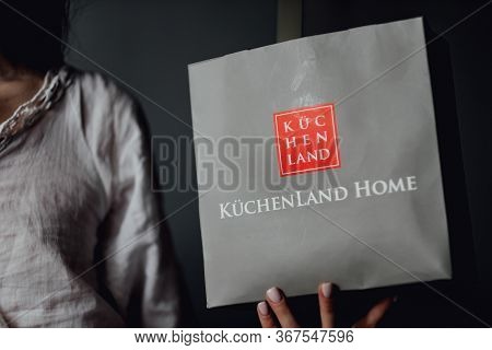 Girl Holding Kuchenland Home Shop Gift Bag , Kuchenland Home Is A Shop From Home And Kitchen Accesso