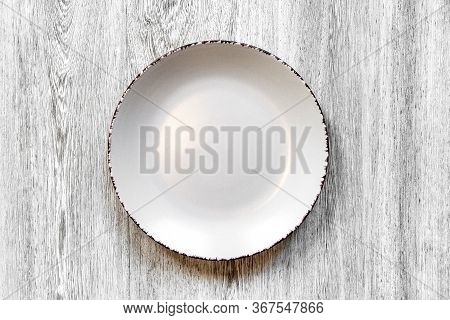 Plate On A Wooden Background Close-up. The View From The Top.