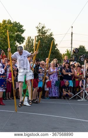 Genichesk, Ukraine - August 26, 2017: Men Compete In Walking On Wooden Stilts During Festival Tavriy
