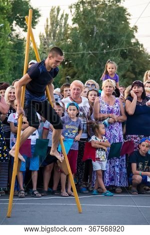 Genichesk, Ukraine - August 26, 2017: Men Compete In Walking On Wooden Stilts During Festival Tavriy