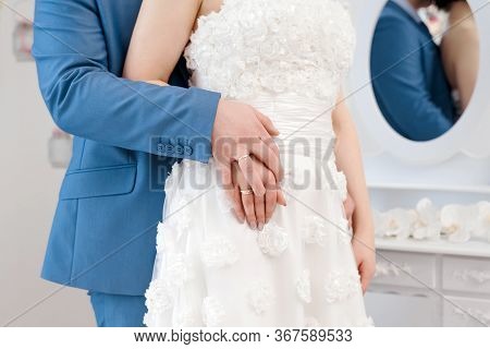 Newly Married Couple Holding Hands With Woman's Hand On Top Of Man's Hand. Wedding