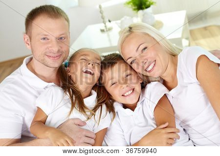 Ritratto di felici genitori e bambini ridendo guardando fotocamera