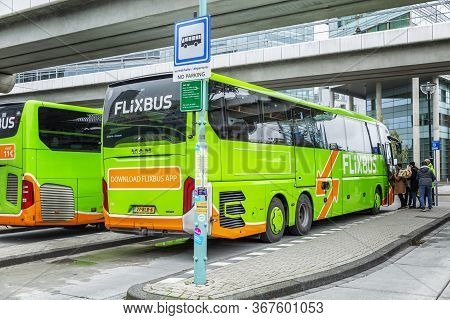 Amsterdam, Netherlands, 10/10/2019: Green International Buses At The Station. A Line Of People Enter