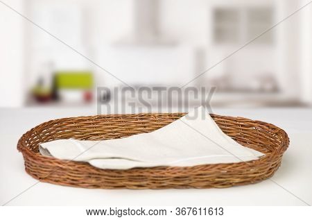 Wicker Oval Basket With A Red Checkered Cotton Napkin Inside On The Table