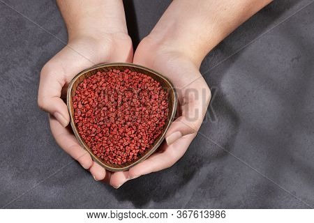 Bixa Orellana - Female Hands Holding The Bowl With Annatto Seeds
