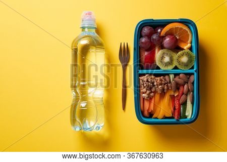 Top View of Full Lunch Box with Fuits, Vegetables and nuts.