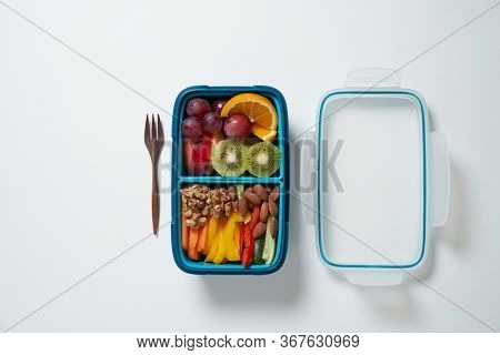 Top View of Full Lunch Box with Fuits, Vegetables and nuts.