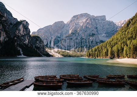 Empty Wooden Boats Moored On The Lago Di Braies On The Background Of Rocky Mountains And Forest. Bra