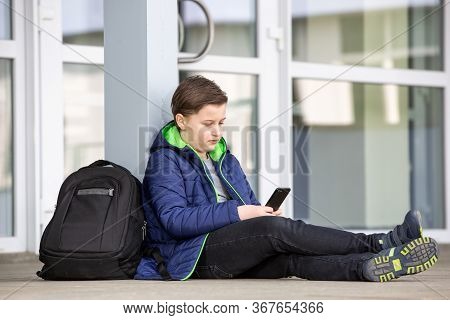 Truancy Concept, Young Boy Staying Away From The School And Playing Games On The Mobile, Absence Fro