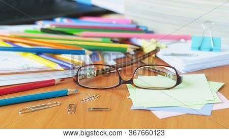 Glasses On The Background Of Colored Pencils And Paper.