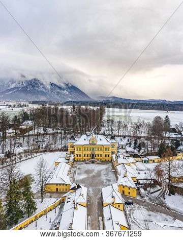 Aerial View Of Schloss Hellbrunn Covered In Snow With View Of Untersberg Near Salzburg Outskirts In 