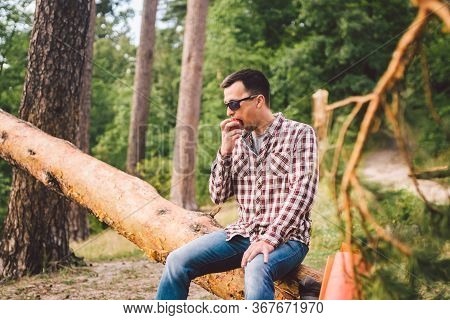 Portrait Young Male Hiker Eating Apple. Tourist At Forest, Stop For Rest And Eat Apple. Fit Man Eati