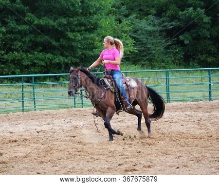 A Female Horse Trainer Riding In An Outdoor Arena