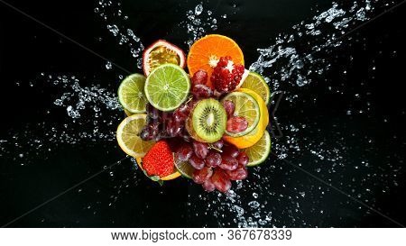Super Slow Motion Shot of Fresh Fruits with Splashing Water Isolated on Black Background.