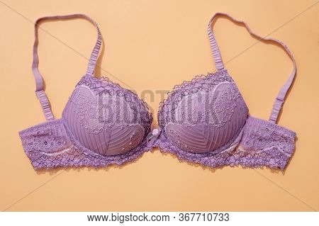 Lilac Bra With Removable Straps On A Beige Background Top View. Sexy Bra With Push Up. Lace Underwea