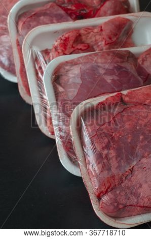 Raw Pork Lungs Packed In Portions. Meat Offal In The Store. Four White Trays Of Fresh Meat. Close-up