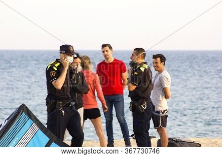 Barcelona, Spain - May 23, 2020: Police Patrolling A Beach And Talking With Kitesurf Sportsmen. Prot