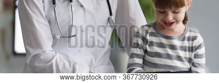 Close-up Of Happy Child With Experienced Pediatrician In Hospital Office. Smiling Little Patient Pai