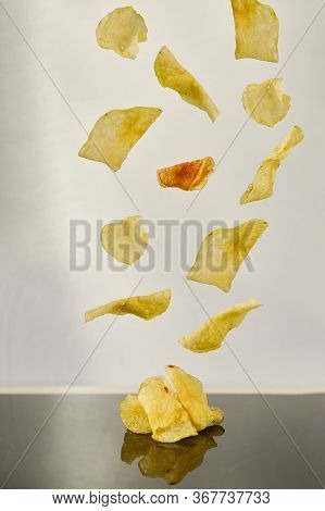 Potato Chips Falling White Background And Black Reflection