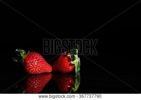 Strawberries On A Black Background With Reflection