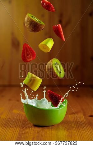 Splash Milk With Fruit Flying And Streeting On A Wooden Background