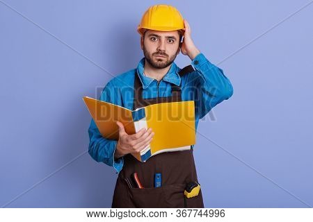 Portrait Of Emotional Magnetic Helpless Young Builder Looking Directly At Camera, Holding Papercase,