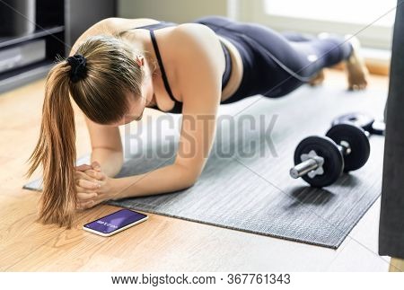 Home Exercise And Bodyweight Training, Plank. Fit Woman Taking Time With Sport Tracker App In Phone.