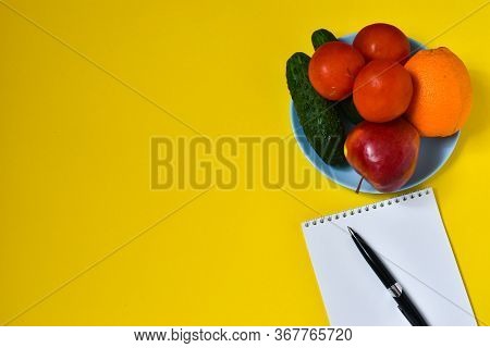 Fruits And Vegetables, Notebook For Notes On A Delt Background. Tomatoes, Cucumbers, Apple, Orange. 