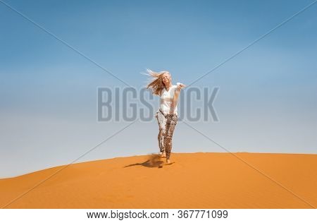 Sporty Woman In Merzouga Dunes Of Sahara Desert Morocco Africa. Travel And Inspiration Concept