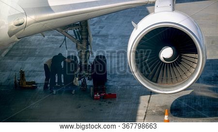 Photo Of Maintenace Ground Crew Checking Airplane Chassis Before Flight