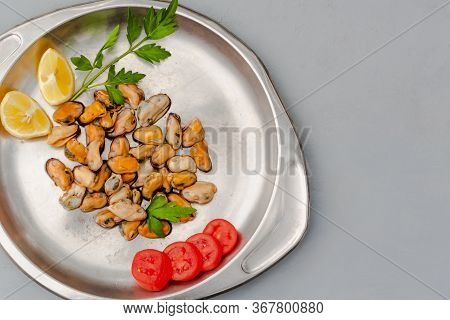 Mussels Without Shell With Tomato Slices And Lemon On A Steel Tray. Seafood Concept. Top View. Space