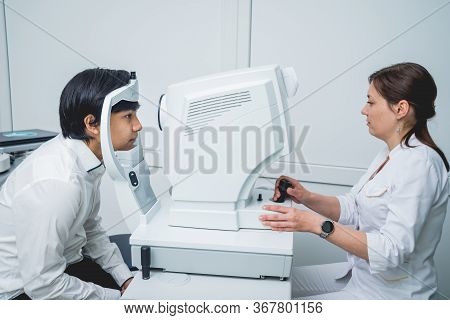 Consultation With An Ophthalmologist. Young Asian Man And Woman Doctor