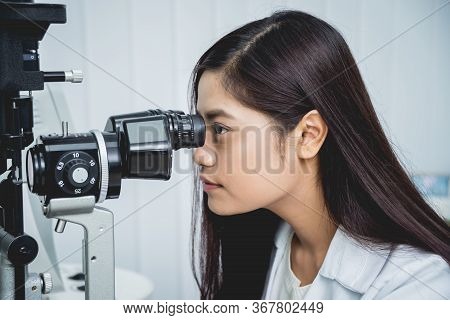 Consultation With An Ophthalmologist. Young Asian Man And Woman Doctor