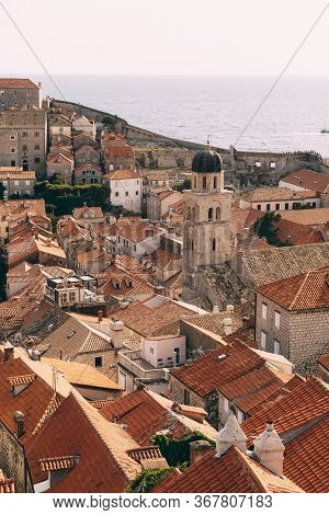 The Bell Tower Of The Franciscan Monastery In Dubrovnik Against The Background Of The Roofs Of The C