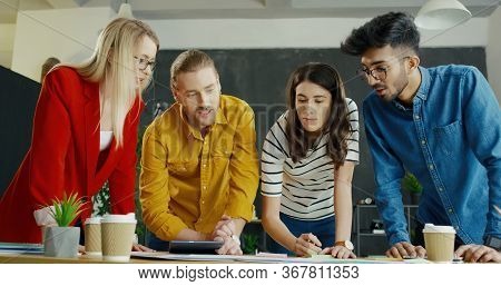 Team Of Multiethnic Male And Female Startuppers Discussin Startup Idea, Strategy And Concept.