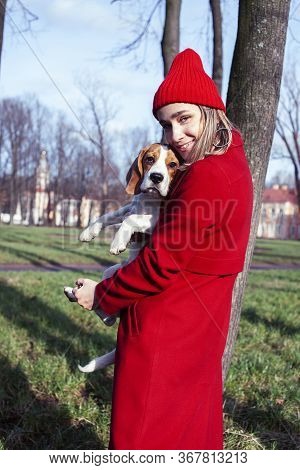 Pretty Young Girl In Redd Coat Playing With Dog Outside In Green Park, Lifestyle People Concept
