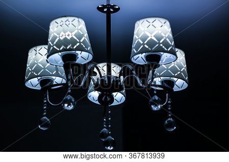 White Lamp With Silver Base On The Ceiling With Deep Shadows