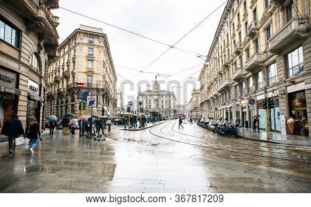 Milan. Italy - May 20, 2019: Street Via Dante and Square Piazza Cordusio in Milan. Rainy Weather. Numerous Passers and Tourists are Walking Along the Decorated Street.