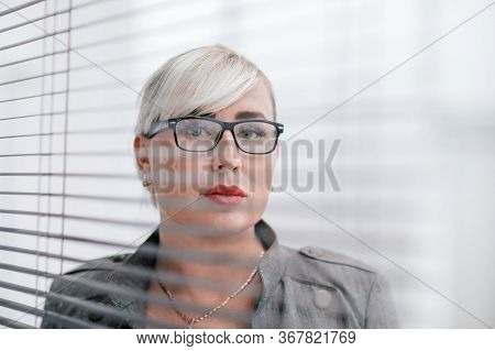 Close Up. Business Woman Looks Somewhere Through The Office Window.