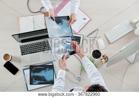 Pulmonologists Comparing Lungs X-rays Of Patient Before And After Medical Treatment In Hospital
