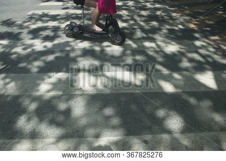 Balneario Camboriu, Santa Catarina, Brazil - November 18, 2019: Woman Driving Electric Scooter Throu
