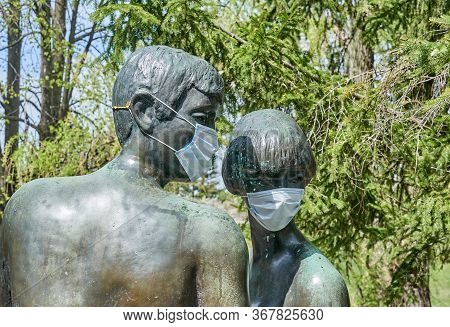 Laval, Canada - May 17, 2020: Statue Of A Man And Woman With Protective Surgical Mask On Them In Cen