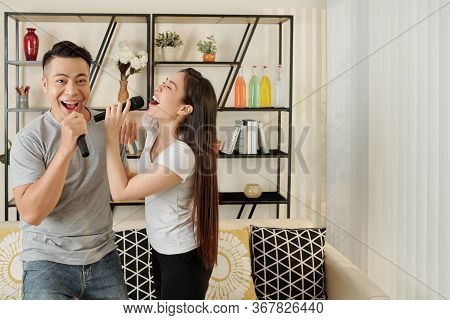 Young Vietnamese Couple Enjoying Singing Karaoke At Home