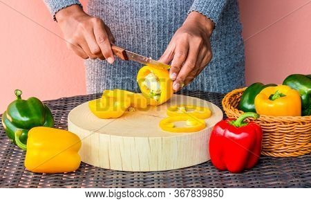 Female Chef Cutting Bell Peppers On Cutting Board