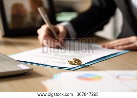 Close Up Of Freelance Woman Hands Signs Divorce Papers Sitting On A Desk At Homeoffice At Night
