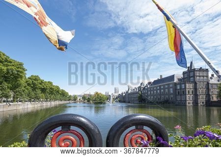 View To The Historical Binnenhof With The Hofvijver Lake, Flags And Flowers In Foreground, Focus On 